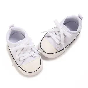 Close-up view of white baby canvas shoes with soft soles for pre-walking babies.