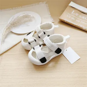 Detailed view of white breathable mesh baby walking sandals with secure velcro straps