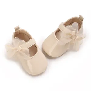 Detailansicht beige Baby-Mary-Janes mit zarter Spitzenschleife und Lackoberfläche