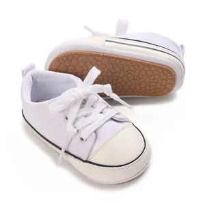 Close-up of white baby canvas shoes with soft non-slip soles and lace-up design