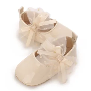 Detailaufnahme beiger Baby-Prinzessinenschuhe mit dekorativer Spitzenschleife und weicher Sohle.