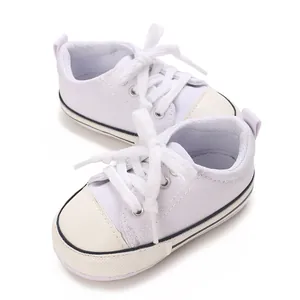 Close-up detail of white infant canvas sneakers with soft soles for pre-walking