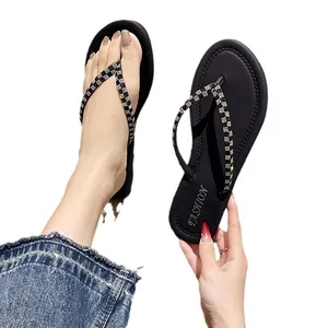 Tongs noires pour femmes avec lanières tressées et bout rond plat de plage