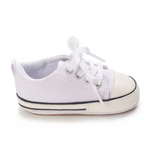 Close-up detail of white baby canvas walker shoe with soft sole and lace-up design