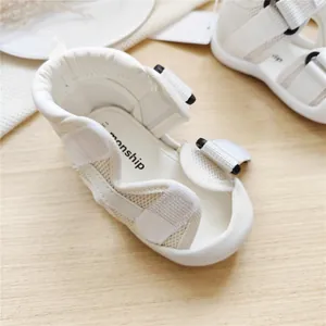 Detail of white baby walking sandals featuring mesh panels and secure velcro straps