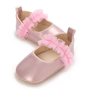 Detaillierte Makroansicht von rosa Metallic-Baby-Mary-Janes mit gerüschten Chiffon-Riemen.
