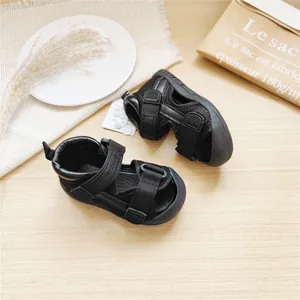 Detailed macro view of black closed-toe baby walking sandals with Velcro straps.