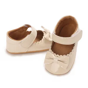 Primer plano de zapatos de princesa beige para bebé con lazo y bordes ondulados