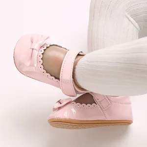 Vista detallada de los zapatos de princesa para bebé en charol rosa con lazo decorativo