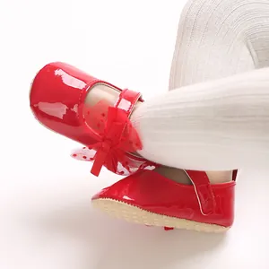 Nahaufnahme rote Lackleder-Babyschuhe mit Schleife und weicher rutschfester Sohle