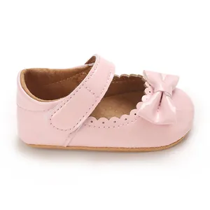Primer plano de zapato de charol rosa para bebé con lazo y bordes ondulados