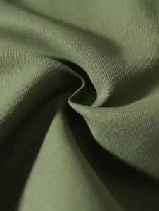 Macro view of olive green woven fabric showing detailed texture and weave for beach shorts.