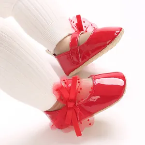 Rote Baby-Lauflernschuhe aus Lackleder für Mädchen mit Schleife und Spitzendetails.