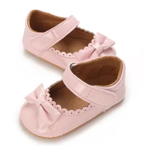 Primer plano de zapatos de princesa rosa para bebé niña con lazo y bordes festoneados