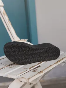 Macro view showing the non-slip wavy texture on a platform wedge sandal outsole detail