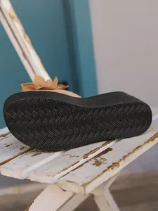 Close-up view of the wavy anti-slip black sole on platform wedge floral summer sandals