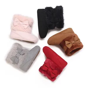 Variety of colorful baby winter boots with faux fur and bow details on white