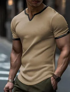 Close-up of men's khaki waffle knit T-shirt featuring a black contrast V-neck collar