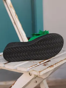 Close-up detail of the anti-slip wavy pattern on a black wedge platform sandal sole