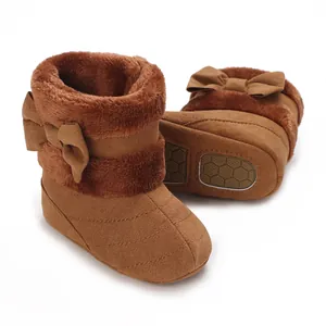 Detailed view of warm brown baby winter boots with soft fur lining and side bow decoration