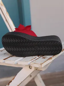 Close-up showing the non-slip wavy texture sole of a red platform floral sandal
