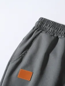 Close-up detail of gray woven beach shorts showing elastic waistband and side pocket