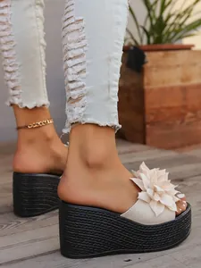 Detailed view of women's white platform sandal with 3D flower and woven black sole