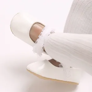 Gros plan de chaussures de princesse blanches pour bébé fille avec dentelle et semelle souple