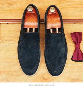 Top-down detail of navy blue suede loafers with elegant wooden shoe trees and red bowtie