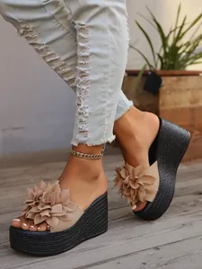Detailed view of women's wedge sandals with 3D flower decoration and platform sole
