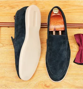Detailed top and sole view of men's navy blue suede loafers with soft beige soles