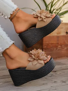 Close-up detail of beige wedge platform sandals featuring a stylish 3D flower ornament