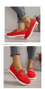 Close-up of red breathable fly-knit shoes with metal chain detail and wedge sole