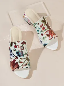Detail view of women's floral embroidered mule sandals with rhinestone block heels
