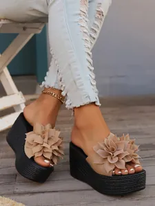 Close-up of summer wedge platform sandals with elegant beige flower decoration