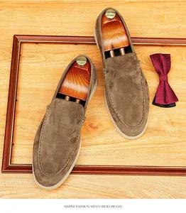 Top view of premium brown suede loafers with wooden shoe trees on a wooden background
