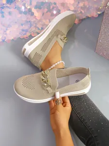 Detailed view of breathable knit loafers with decorative gold-tone chain accent.