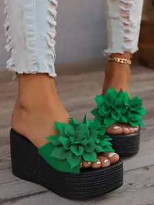 Detail shot of the vibrant green flower decoration on high platform wedge sandals