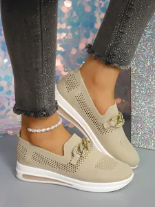 Close-up of beige knitted loafers with gold chain and breathable hollow mesh design.