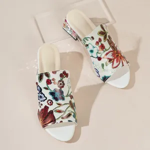 Elegant white slides for women with vibrant floral embroidery and decorative block heel