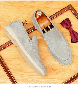 Detail shot of elegant grey suede men's loafers with soft sole on wooden background