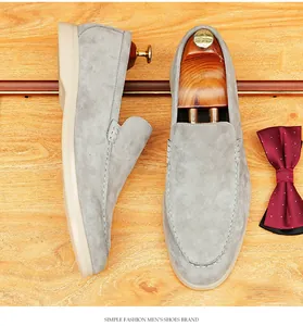 Close-up of grey suede men's loafers with soft sole on wooden background