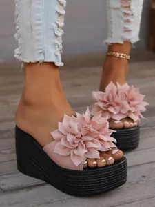 Close-up of pink flower wedge sandals featuring a thick black braided platform sole.
