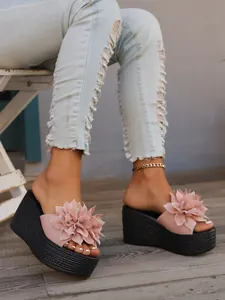 Pink platform wedge sandals featuring stylish 3D floral details and a comfortable woven sole.