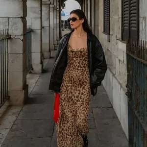 Abito sottoveste leopardato alla moda con giacca in pelle nera in un contesto street