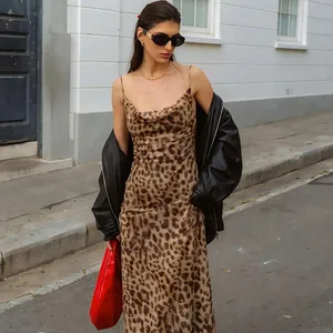 Elegante abito sottoveste leopardato con scollo a cappuccio e giacca di pelle nera in città.