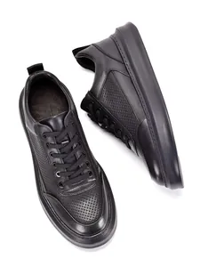 Primer plano de zapatillas de moda para hombre en cuero negro perforado de primera calidad