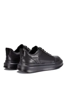 Vista trasera de zapatillas de negocios en cuero negro transpirable con suelas gruesas.