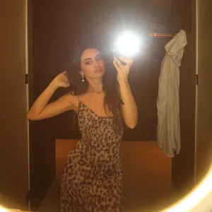Vestito sexy con stampa leopardata, scollo a V e schiena scoperta in un selfie caldo.