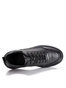 Detalle superior de zapatos casuales de hombre en cuero negro perforado y transpirable.